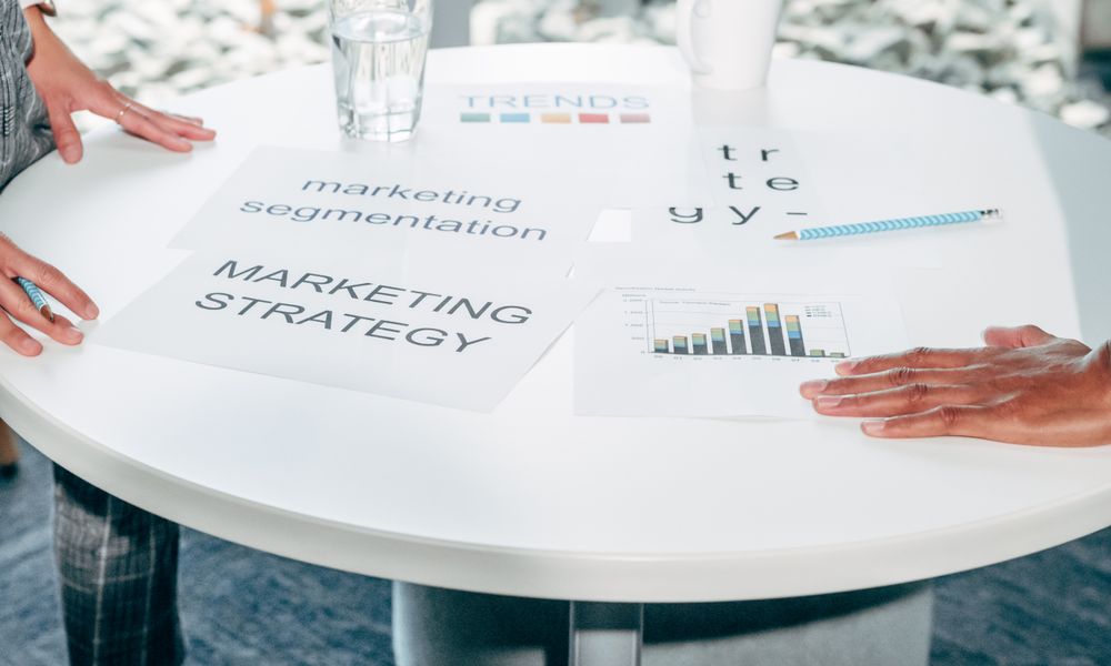 Two professionals collaborate on marketing strategy and segmentation at a round table.