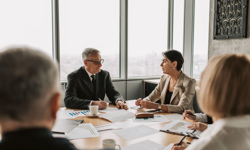 Business professionals engaged in a strategic meeting in a modern office setting with natural light.
