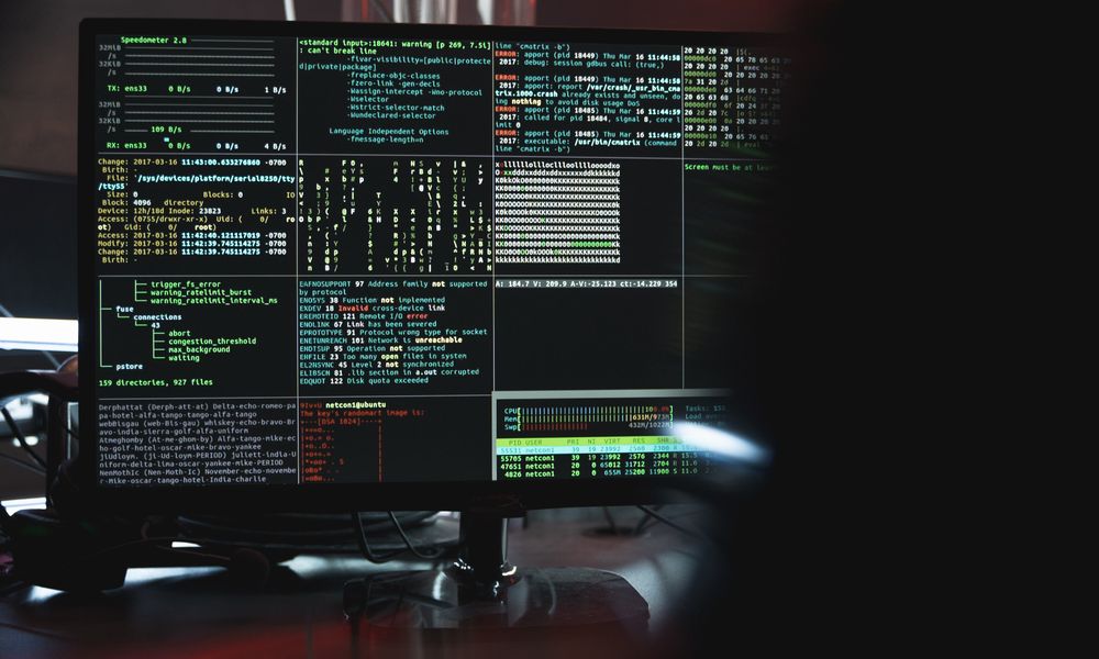 Close-up of a computer monitor displaying cyber security data and code, indicative of system hacking or programming.