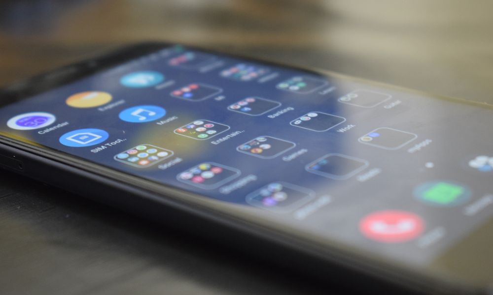 Close-up shot of a smartphone screen showing various app icons, indicating digital technology use.