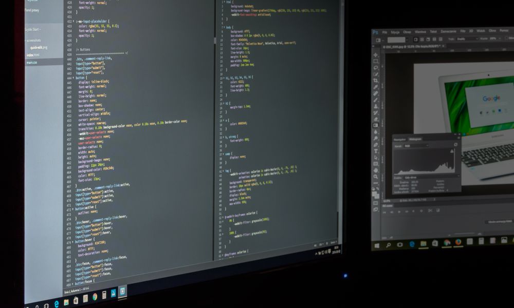 A dual screen setup showcasing programming code and image editing software.