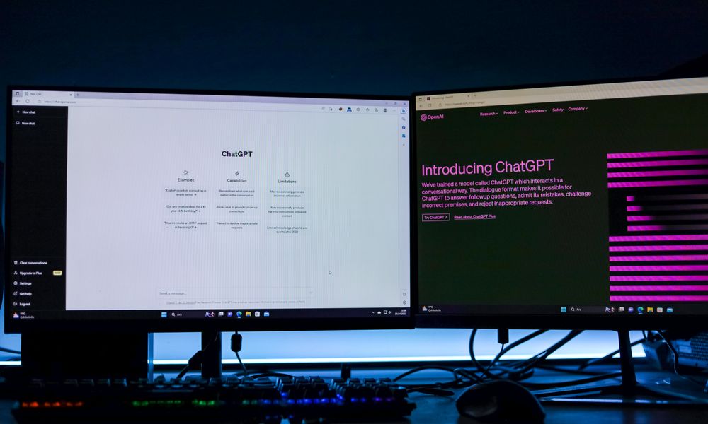 Dual computer monitors showcasing a chat interface in a technology workspace setting.