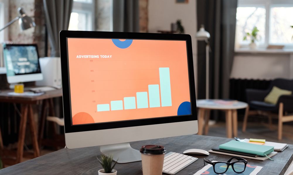 Contemporary office desk setup with computer displaying a business chart.