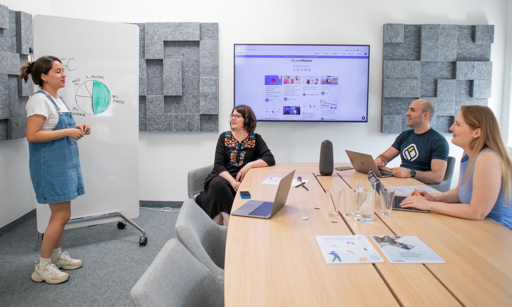 Team collaborating during a meeting with presentation and discussion in a modern office.