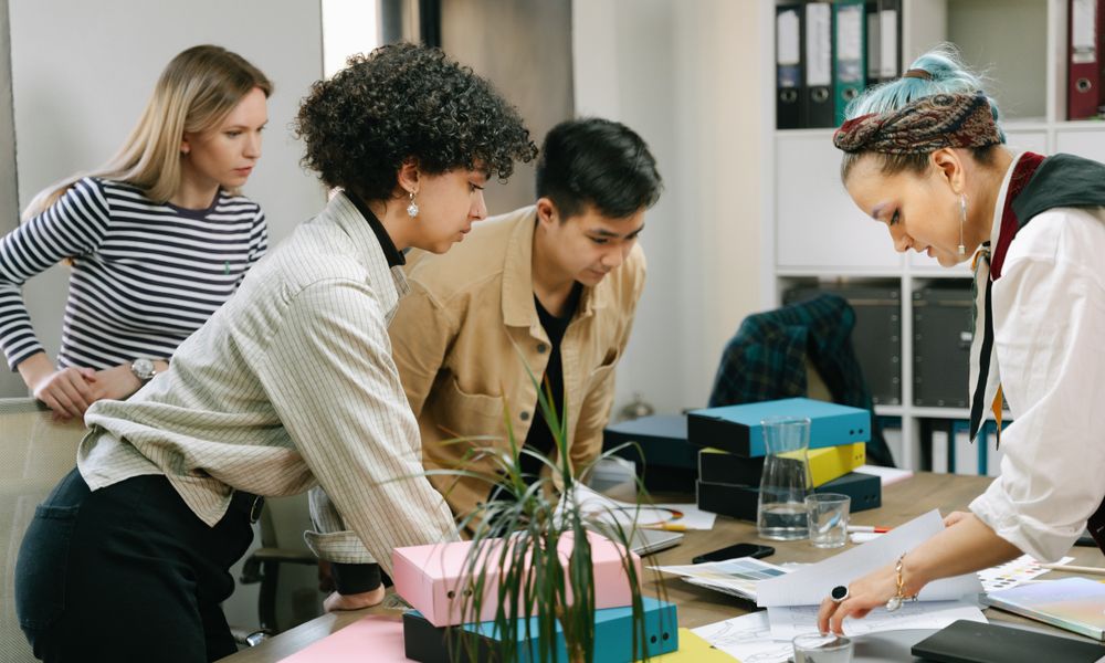 A diverse team of colleagues collaborating on a business project in a modern office setting.