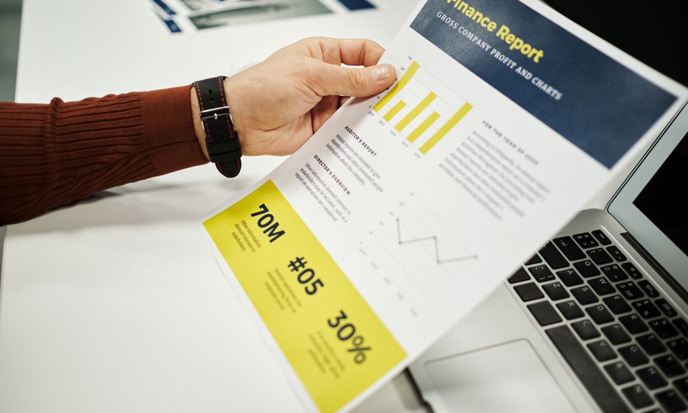 Person analyzing finance report with graphs at desk, ideal for business concepts.