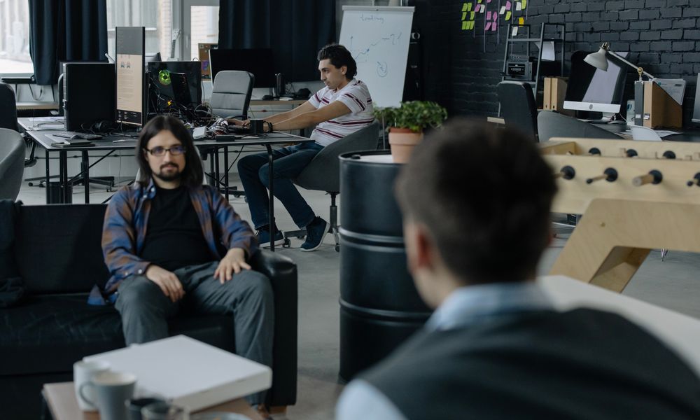 Team of professionals collaborating in a modern open office space with multiple workstations.