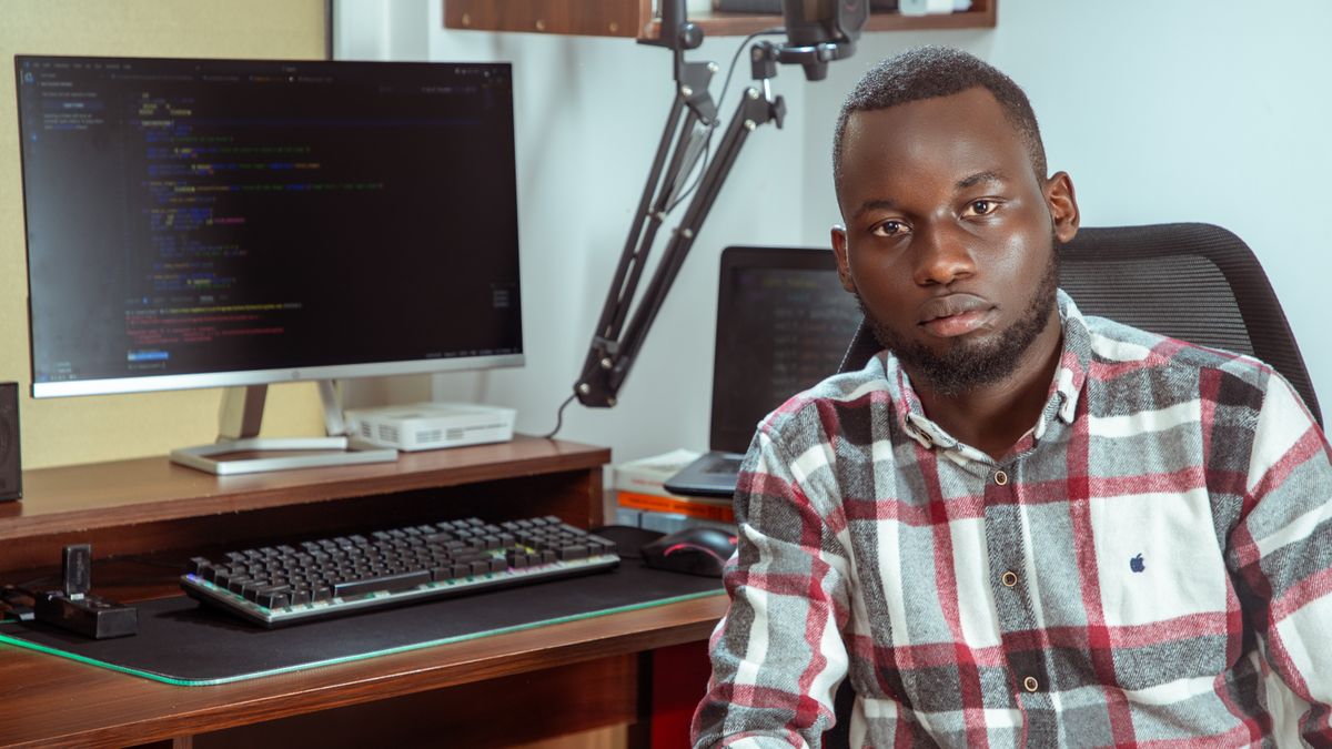 Portrait of a developer coding in a modern office setting, showcasing technology and focus.